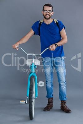 Man in blue t-shirt and backpack with a bicycle