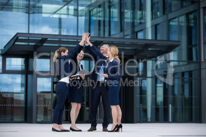 Happy businesspeople giving high five to each other