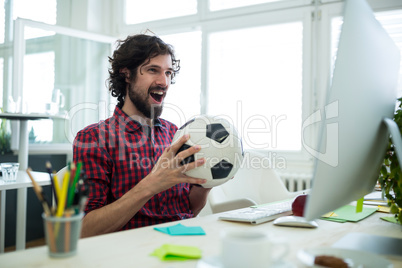 Business executive watching a football match on computer