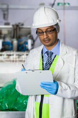 Technician writing on clipboard