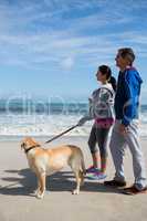 Couple standing with pet their dog