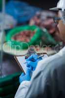 Technicians maintaining records on clipboard