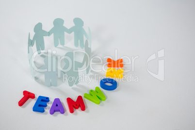 Circle of paper cut-out figures with teamwork word