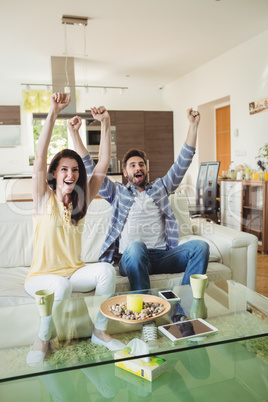 Excited couple watching tv together