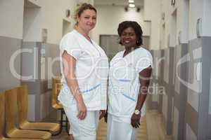 Portrait of two female nurse standing in corridor