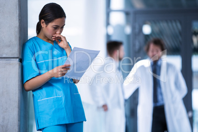 Thoughtful nurse examining a medical report