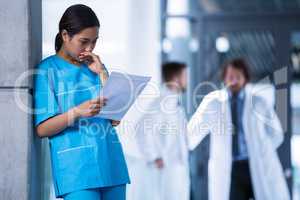 Thoughtful nurse examining a medical report