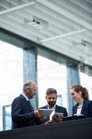 Businesspeople discussing over digital tablet