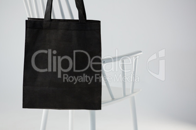 Black bag hanging on a white chair