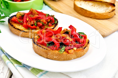 Bruschetta with tomatoes and peppers in plate on board