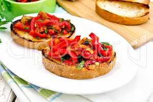 Bruschetta with tomatoes and peppers in plate on board
