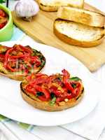 Bruschetta with vegetables in plate on board