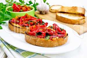 Bruschetta with vegetables in plate on light board