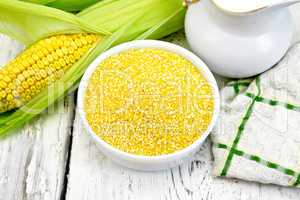 Corn grits in white bowl on board