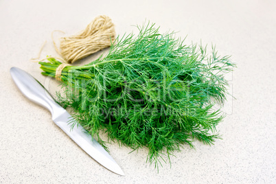 Dill with twine and knife on granite table