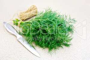 Dill with twine and knife on granite table