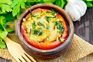 Fish baked with tomato and garlic in clay bowl on board