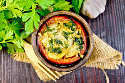 Fish baked with tomato in clay bowl on dark board top