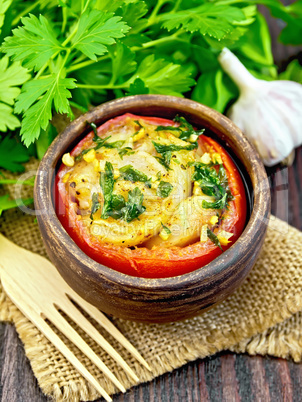 Fish baked with tomato in clay bowl on dark board