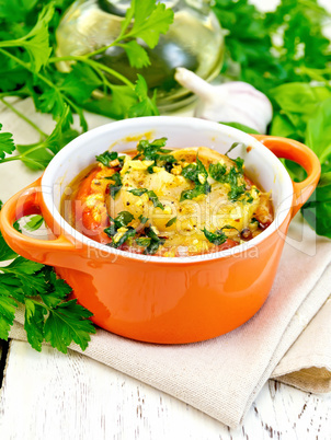 Fish baked with tomato in red pot on light board