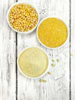 Flour and grits corn in bowls on board top