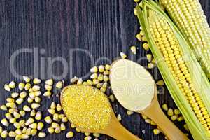 Flour and grits corn in spoons on wooden board