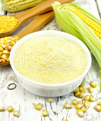 Flour corn in bowl with cobs on board
