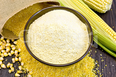 Flour corn in bowl with grits and cob on dark board