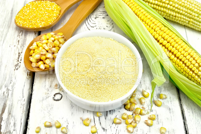 Flour corn in bowl with spoons on board