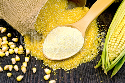 Flour corn in spoon with grains on dark board