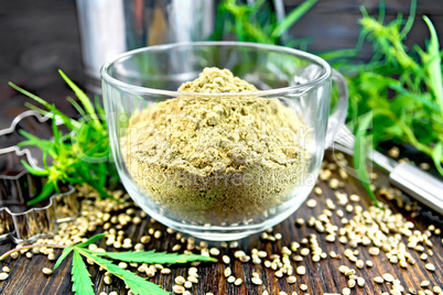 Flour hemp in glass cup on dark board