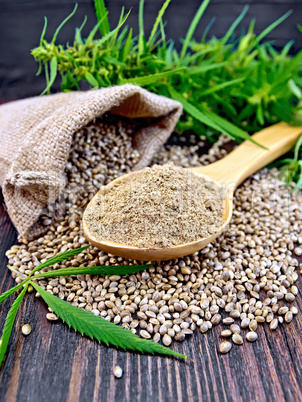 Flour hemp in spoon with leaf on board