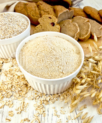 Flour oat and bran in white bowl with bread on board