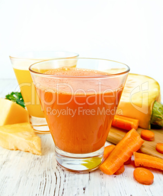 Juice carrot and pumpkin with vegetables on light board
