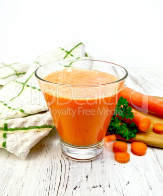 Juice carrot with vegetables and napkin on light board