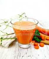 Juice carrot with vegetables and napkin on light board