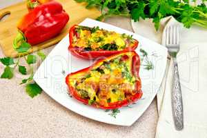 Pepper stuffed with sausage and cheese in plate on granite table