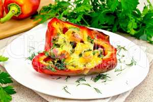 Pepper stuffed with sausage and cheese in plate on stone table