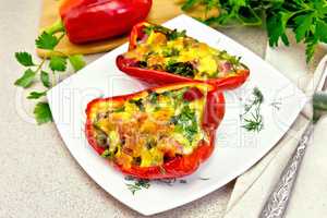 Pepper stuffed with sausage and cheese in white plate on granite