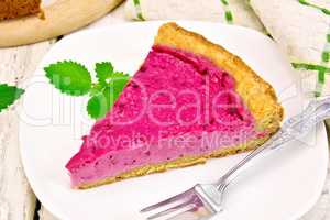 Pie of black currants with mint in plate on board