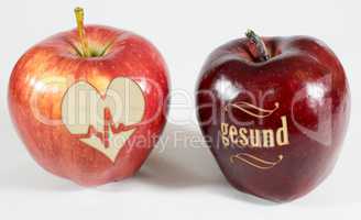 1 Apfel mit der Aufschrift gesund und ein Apfel mit einem Herz