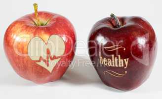 1 Apfel mit der Aufschrift healthy und ein Apfel mit einem Herz