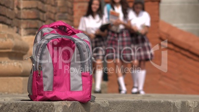 Female Students Walking Towards Backpack