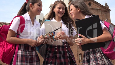 Teen Female Students Talking And Holding Books