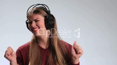 Joyful woman listening music in headphones