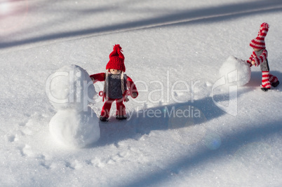 Two toy little man rolled a snowball