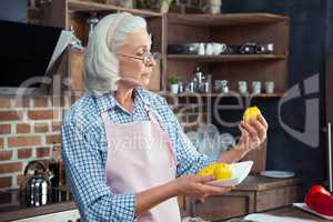 Woman looking at lemons in kitchen