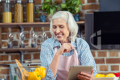 Woman using digital tablet in kitchen