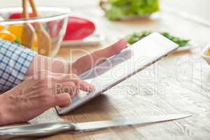 Woman using digital tablet in kitchen