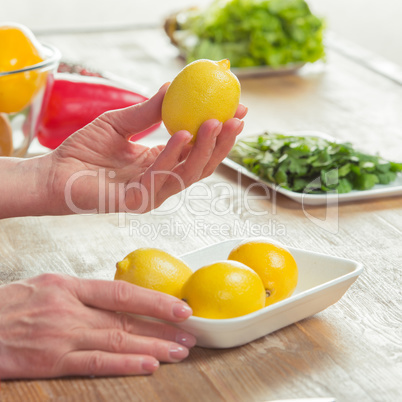 Female hands inspecting lemons